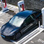 Czarny Tesla ładowany przy stacji w nowoczesnym centrum miasta