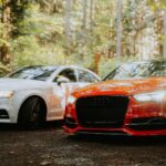 Czerwone i białe Audi zaparkowane w lesie, test opon całorocznych